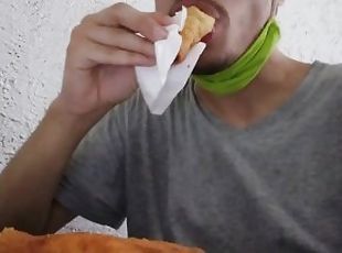 Cara comendo enroladinho