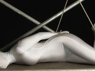 Babe wrapped in white zentai suit enjoys to be bondaged to a metal pole